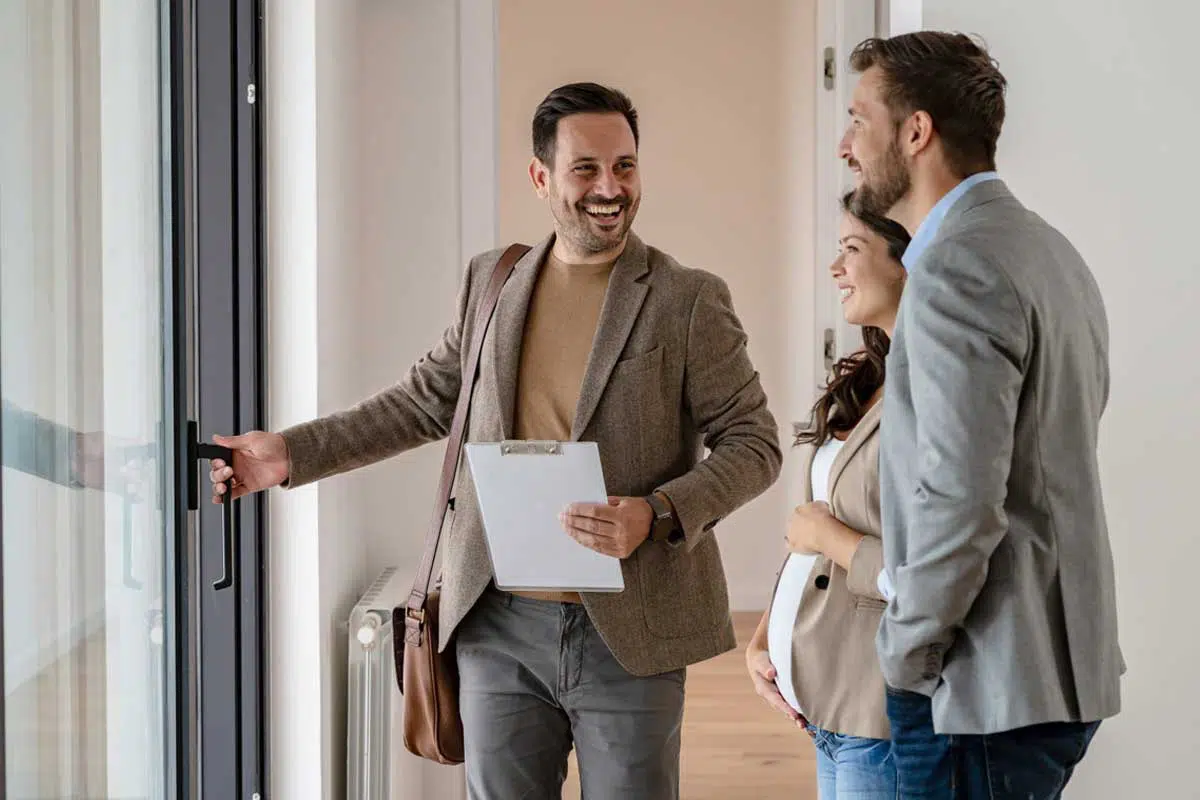 Visite d’appartement avec l’agence Yokey – service sans commission Agent immobilier Yokey ouvrant la porte pour une visite d’appartement avec des clients, forfait fixe sans commission